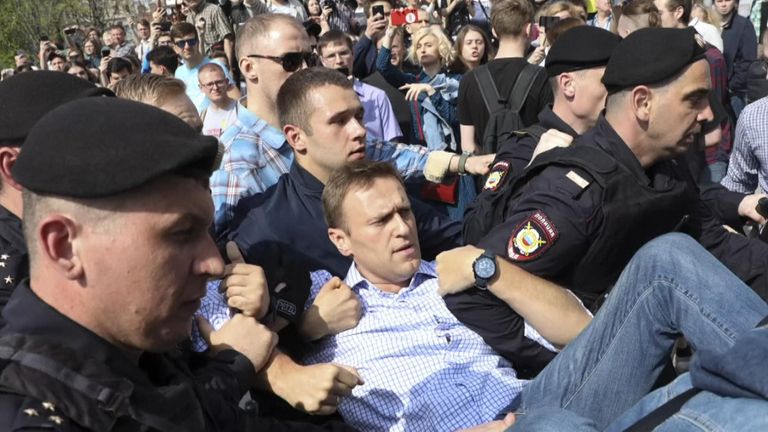 Russian police police carrying struggling opposition leader Alexei Navalny, centre, at a demonstration against President Vladimir Putin in Pushkin Square