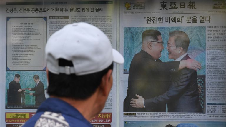 A man walks past a newspaper featuring a front page story about the summit