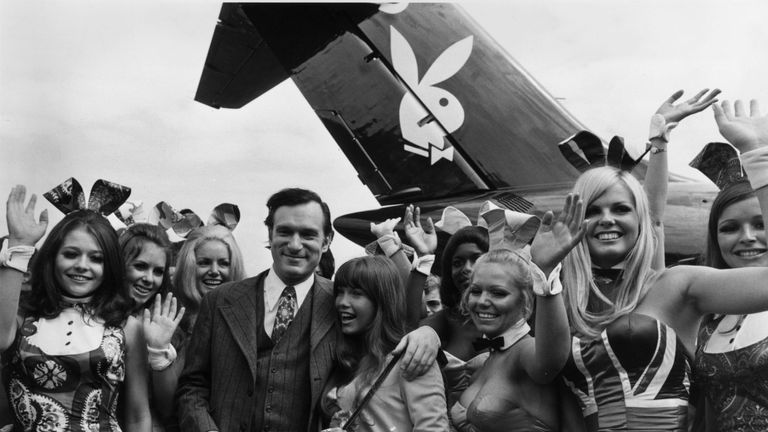 Hugh Hefner stand in front of a plane complete with the iconic Playboy logo