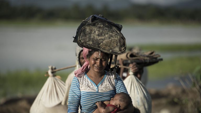 PSHOT - Rohingya refugee cries as she walks after crossing the Naf river from Myanmar into Bangladesh in Whaikhyang on October 9, 2017. A top UN official said on October 7 Bangladesh's plan to build the world's biggest refugee camp for 800,000-plus Rohingya Muslims was dangerous because overcrowding could heighten the risks of deadly diseases spreading quickly. The arrival of more than half a million Rohingya refugees who have fled an army crackdown in Myanmar's troubled Rakhine state since Augu