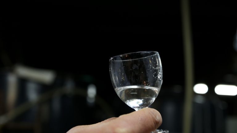 HIMEJI, JAPAN - JANUARY 22: Japanese sake brewery worker holds up a glass of freshly made sake at Tanaka Sake Brewery on January 22, 2014 in Himeji, Japan. Japanese Prime Minister Shinzo Abe targets 60 billion yen by 2020, a fivefold increase in rice-based product exports including sake. (Photo by Buddhika Weerasinghe/Getty Images)
