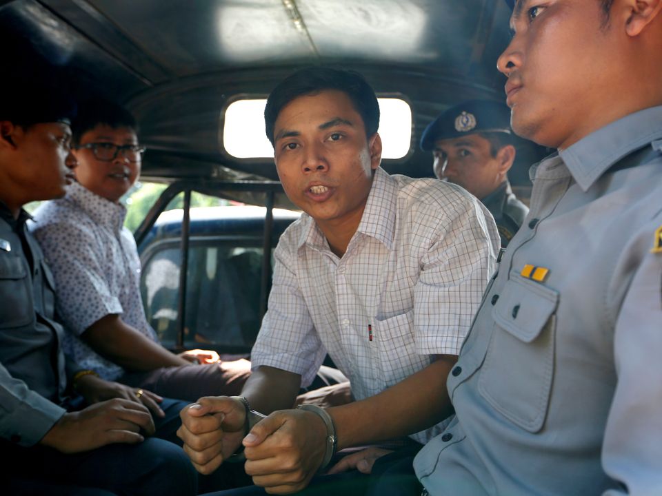 Detained Reuters journalist Kyaw Soe Oo (R) and Wa Lone (L) are transport in a police vehicle after a court hearing...