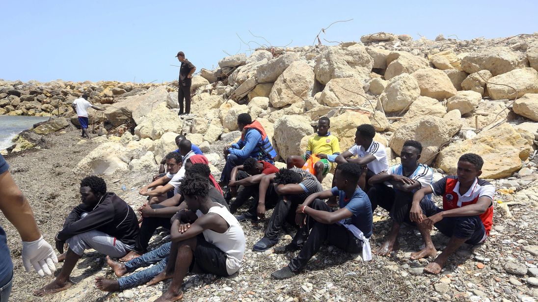Migrants who survived the sinking of an inflatable dinghy boat off of the coast of Libya arrive on the shore of al-Hmidiya east of the capital Tripoli