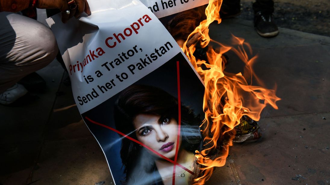 A burning poster describing Chopra as a traitor
