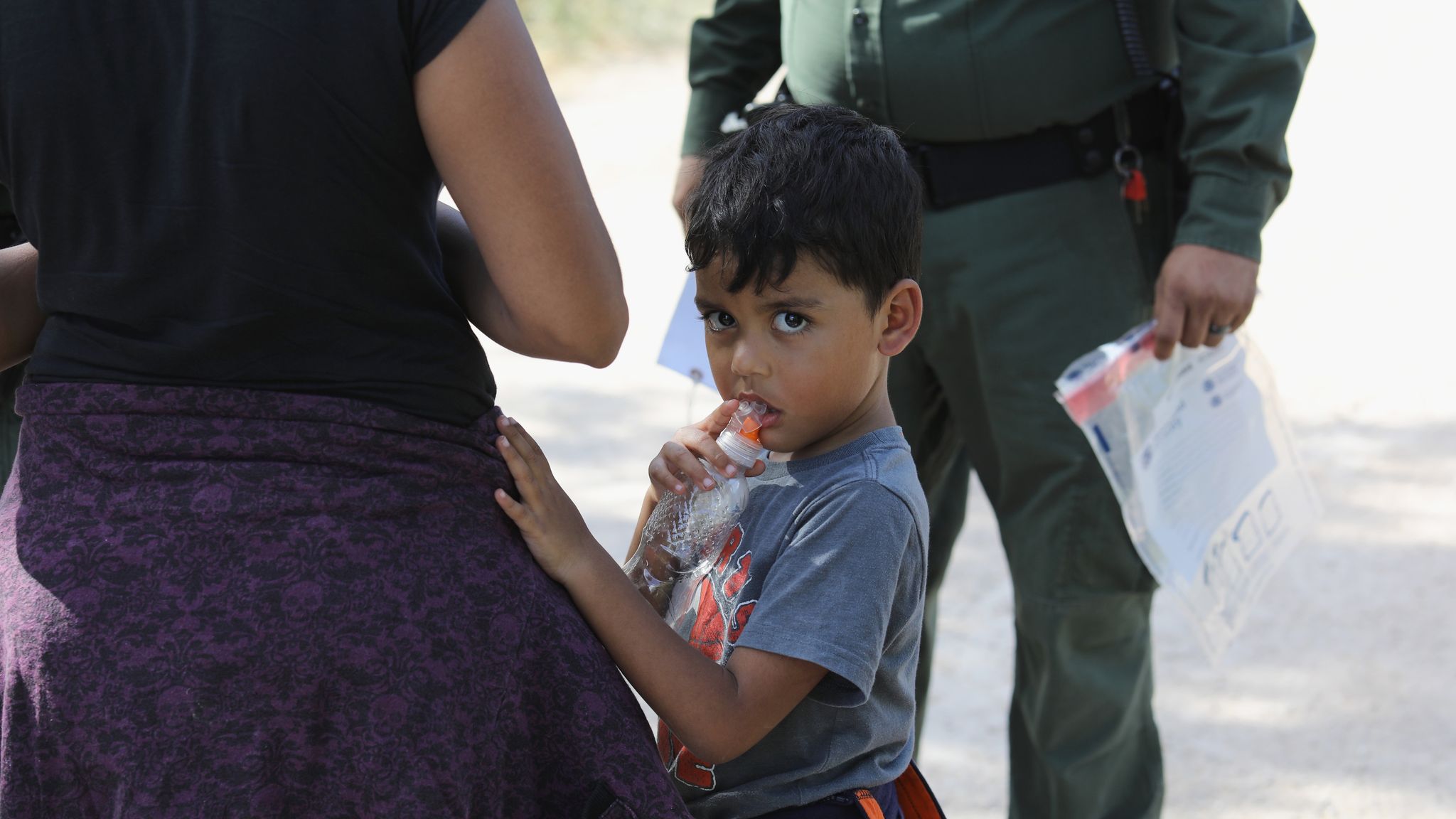 Away from the children. Police take children. Family Separation+migrant. Family Separation. The stranger takes the child away.