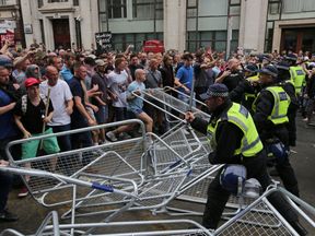 Protesters scuffle with police at the junction of Whitehall and The Mall during a gathering by supporters of far-right spokesman Tommy Robinson in central London on June 9, 2018, following the jailing of Tommy Robinson for contempt of court. (Photo by Daniel LEAL-OLIVAS / AFP) (Photo credit should read DANIEL LEAL-OLIVAS/AFP/Getty Images)
