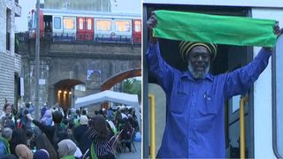 The train driver held up a green scarf in tribute to the Grenfell anniversary gathering