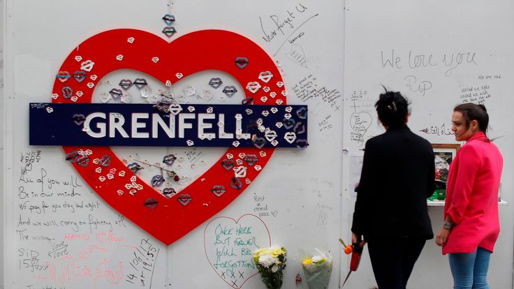 Messages of condolence for the victims of the Grenfell Tower fire are pictured on a fence near to the burned-out shell of the tower