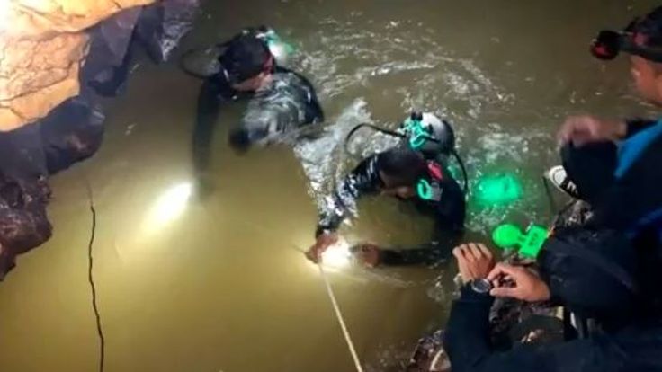 Divers making their way through water in the tunnels of the complex
