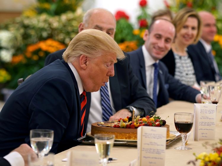 Donald Trump blows out the candle on his birthday cake