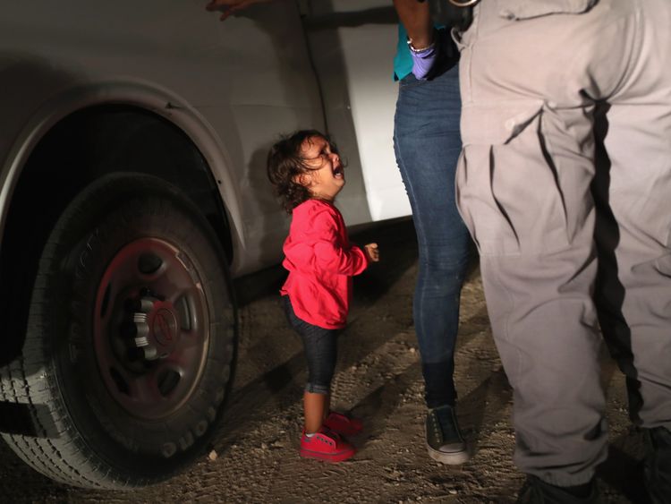 A two year old Honduran asylum seeker cries as her mother is searched and detained