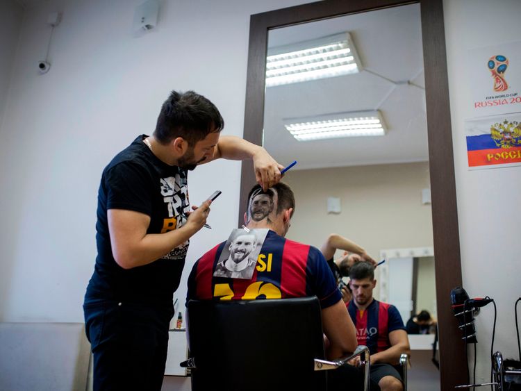 A football fan sports a hair tattoo showing the portrait of Argentinian football player Lionel Messi