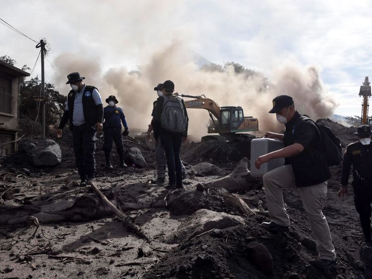 Police officers search for victims of the Fuego Volcano eruption