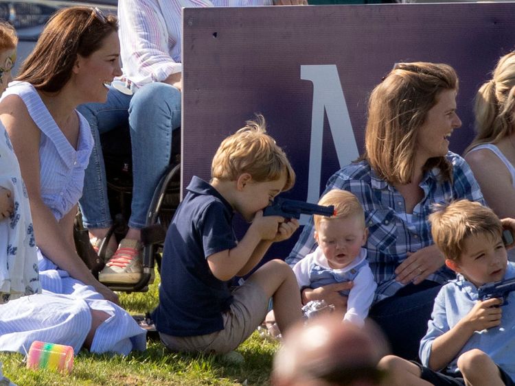 Prince George plays with a toy gun as he sits with his mother the Duchess of Cambridge (left), whilst his father the Duke of Cambridge takes part in the Maserati Royal Charity Polo Trophy at the Beaufort Polo Club, Downfarm House, Westonbirt, Tetbury. 