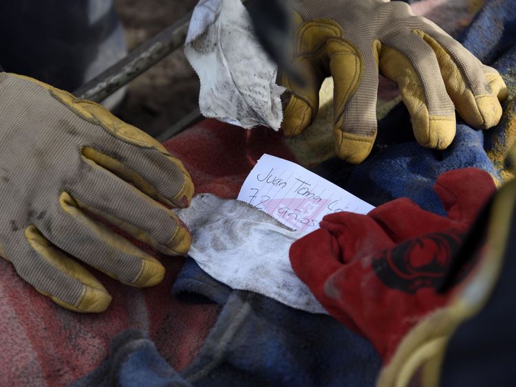 Firefighters identify a victim during the search in San Miguel Los Lotes