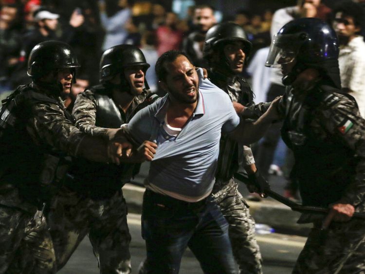 Members of the Jordanian gendarmerie detain a protester 