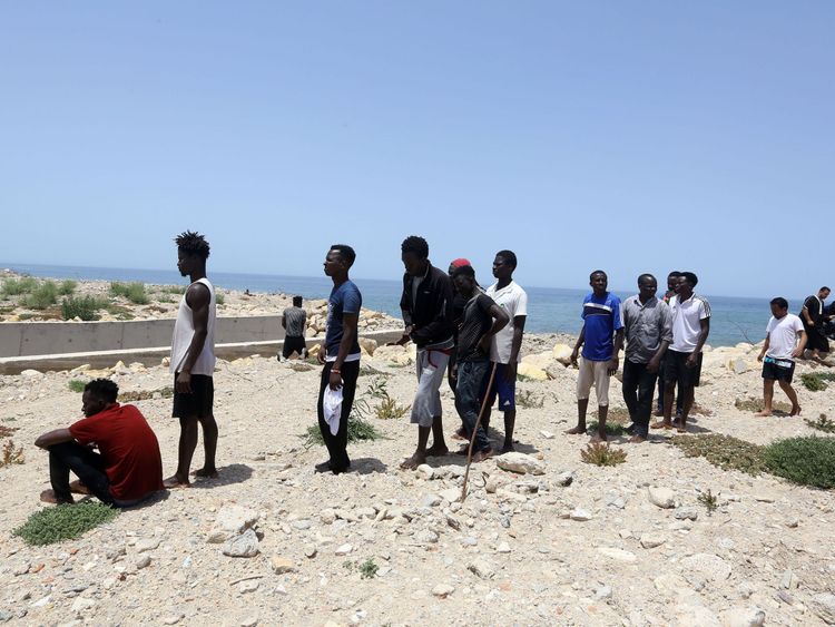 Migrants who survived the sinking of an inflatable dinghy boat off of the coast of Libya arrive on the shore of al-Hmidiya east of the capital Tripoli