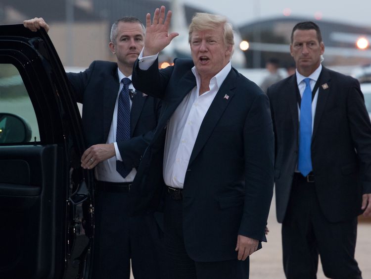 Donald Trump waves as he steps off Air Force One on his return to the US