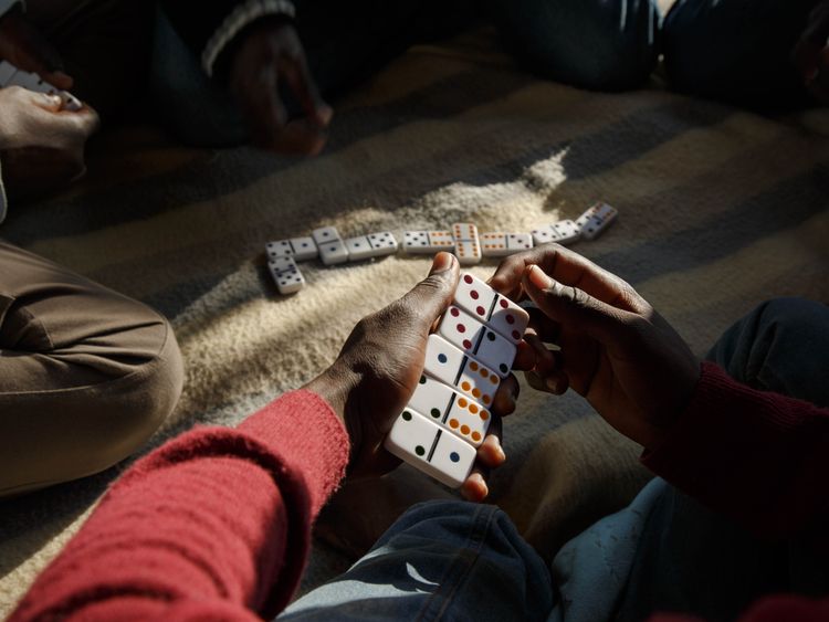 Migrants playing dominoes under a flyover in Ventimiglia. Pic: Oxfam/Agostino Loffredi