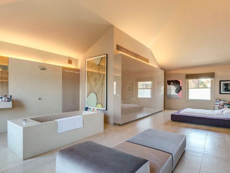 The open-plan bathroom boasts a cast stone bath