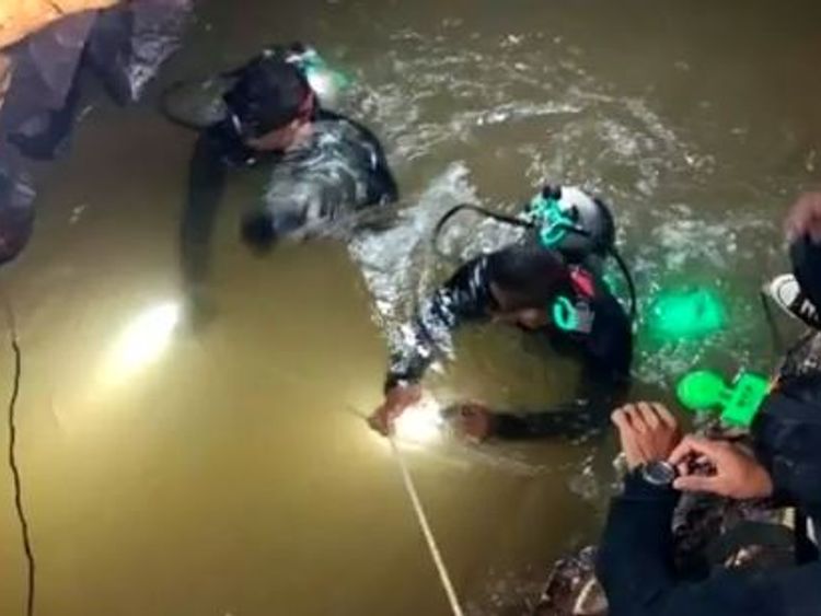 Divers making their way through water in the tunnels of the complex