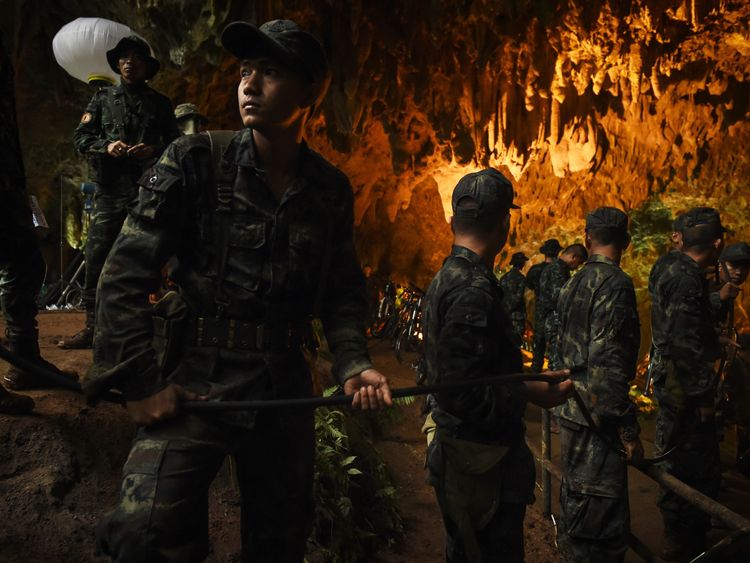 Thai soldiers relay electric cable deep into the Tham Luang cave