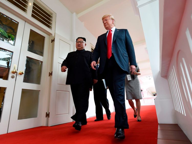 Kim Jong Un and Donald Trump walk together as their one-on-one meeting begins