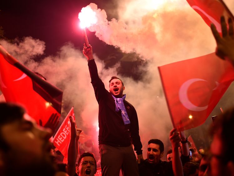 People let off flares outside the AKP party's headquarters in Istanbul