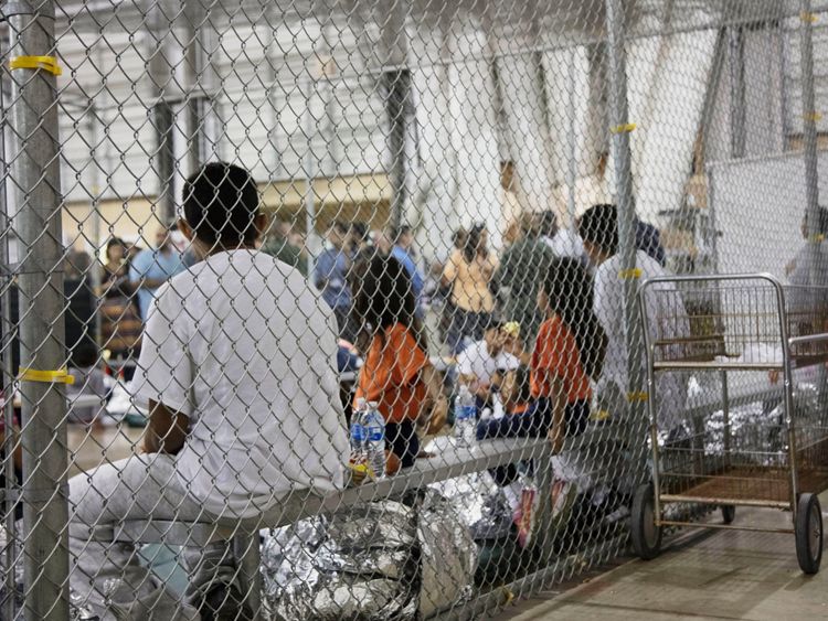 People sit in cages in the facility