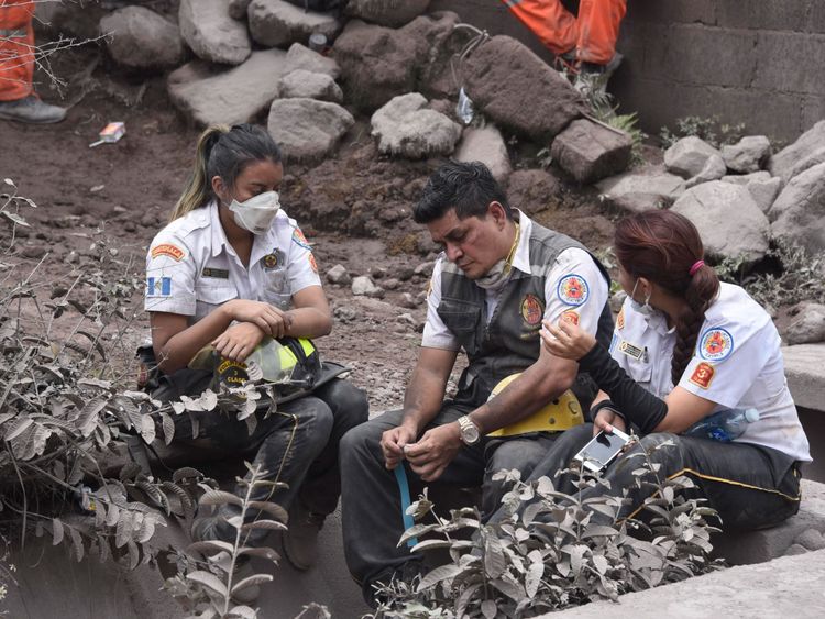 Emergency service staff take a break during the exhausting search for survivors