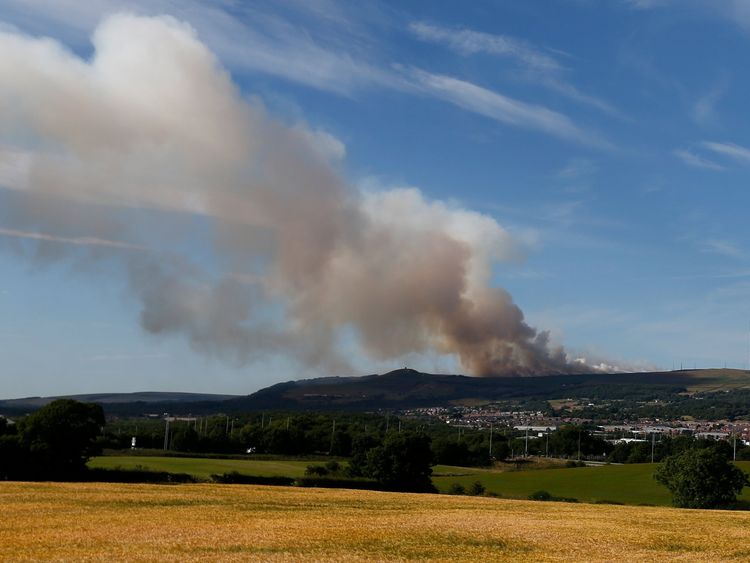 Smoke rises from a grass fire on Winter Hill near Bolton