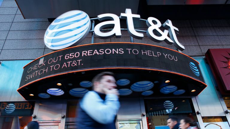People walk past an AT&T store in New York on October 23, 2016