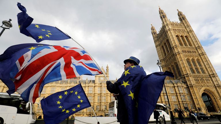 An anti-Brexit demonstrator waves a Union flag alongside a European Union flag outside the Houses of Parliament