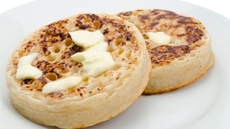 Two hot crumpets with melting butter - studio shot with a shallow depth of field and a white background