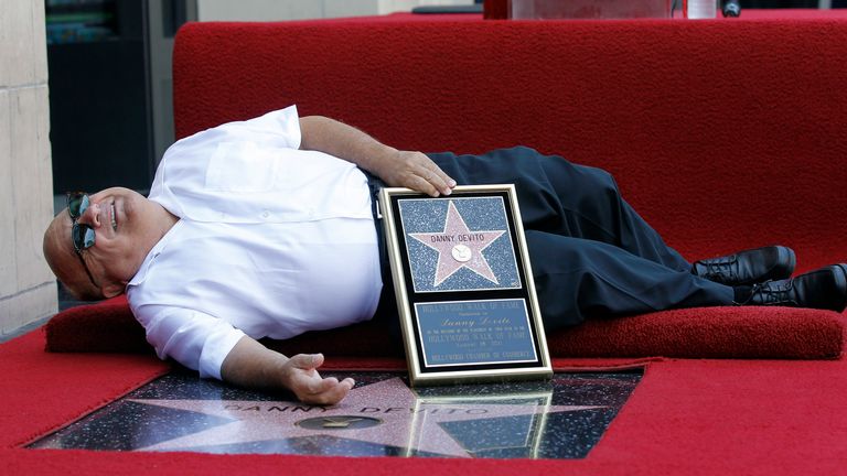 Actor Danny DeVito lies down by his star