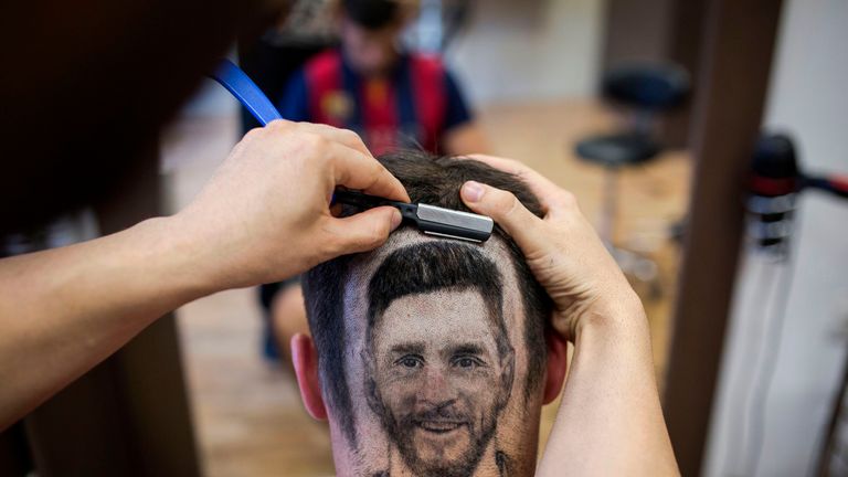 A football fan sports a hair tattoo showing the portrait of Argentinian football player Lionel Messi 