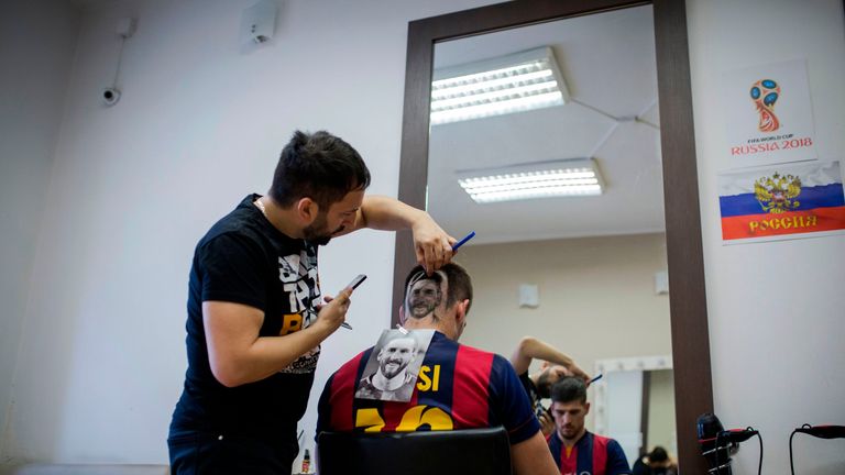 A football fan sports a hair tattoo showing the portrait of Argentinian football player Lionel Messi 