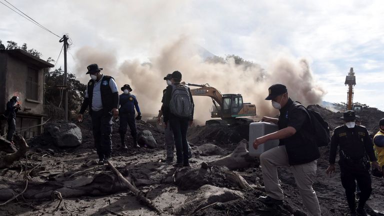 Police officers search for victims of the Fuego Volcano eruption