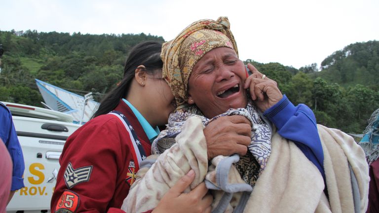 A woman cries as she finds out her family are listed as missing at the Lake Toba ferry port