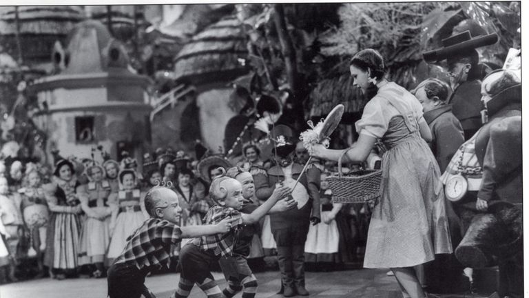 Jerry Maren presents Judy Garland with a lollipop in the film The Wizard of Oz.
