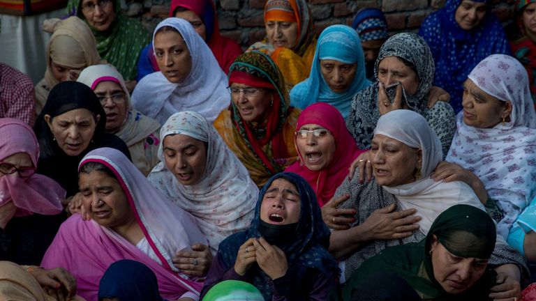 Kashmiri women grieve near the body of Qaiser Amin Bhat, during his funeral 