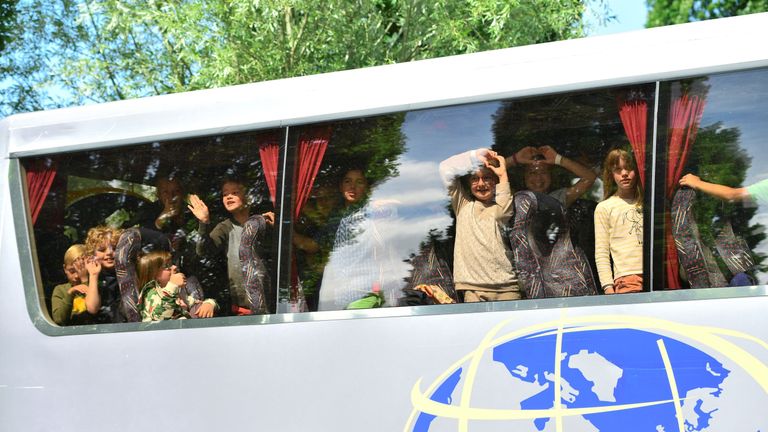 Pupils on a school trip look out from their bus as it has to remain in the parking lot