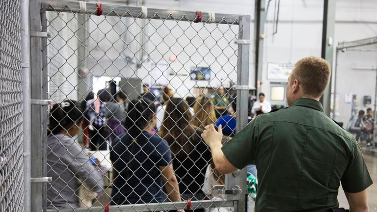 A Border Patrol agent watches detainees
