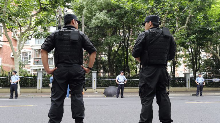 Police officers stand guard at the scene after a man armed with a knife attacked students 