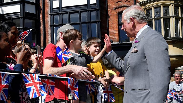 Prince Charles gives a high five during his visit
