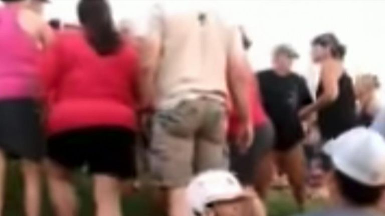 A girl attempts to stop the brawl between parents at the softball tournament in Tennessee