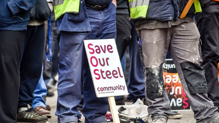 A placards is rested by steelworkers feet as they wait to meet Secretary of State for Business