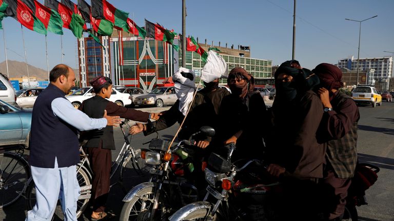 Taliban on motorbikes shake hands with Afghans in Kabul