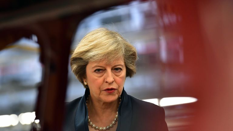 Theresa May views a car on a production line during a visit to the Jaguar Land Rover factory