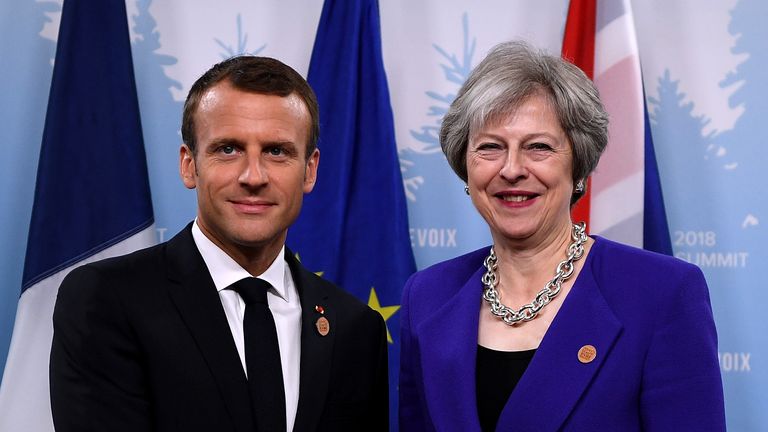 Theresa May poses for a photo with French President Emmanuel Macron on day one of the G7 meeting in Quebec, Canada